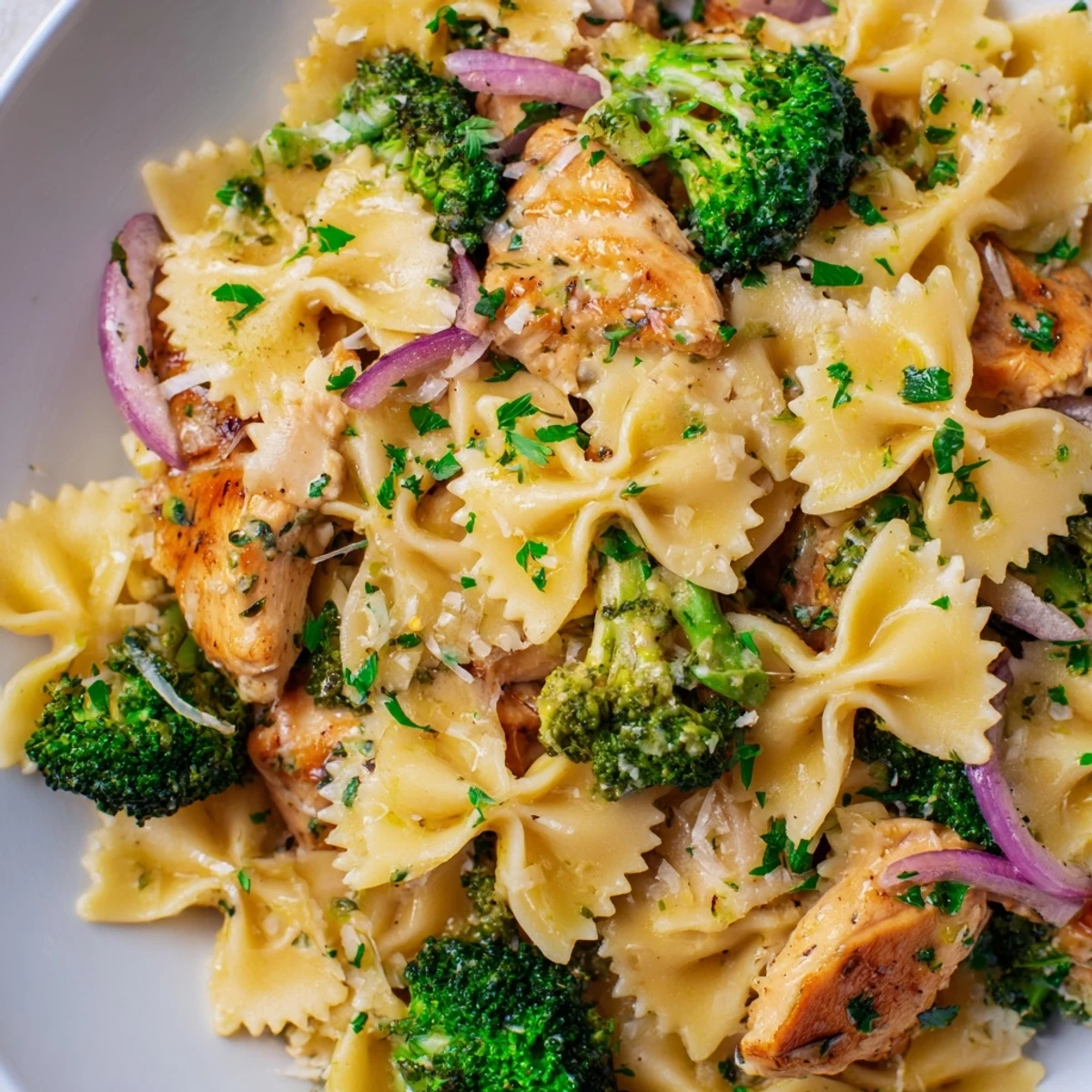 Savory chicken broccoli bowtie pasta coated in tangy lemon cowboy butter sauce with fresh herbs and parmesan