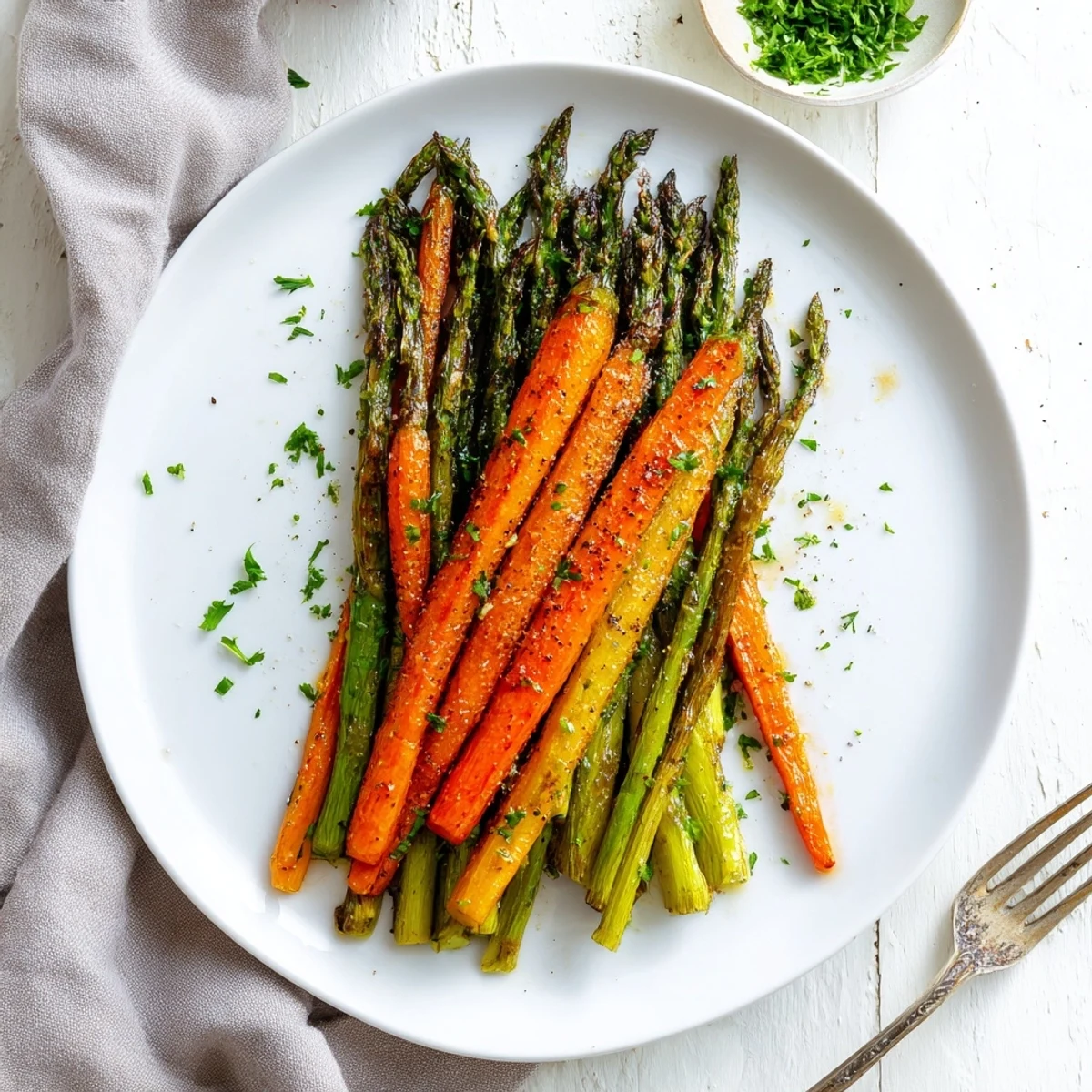 Tender roasted asparagus and sweet carrot sticks perfectly cooked with golden edges and aromatic garlic herb seasoning