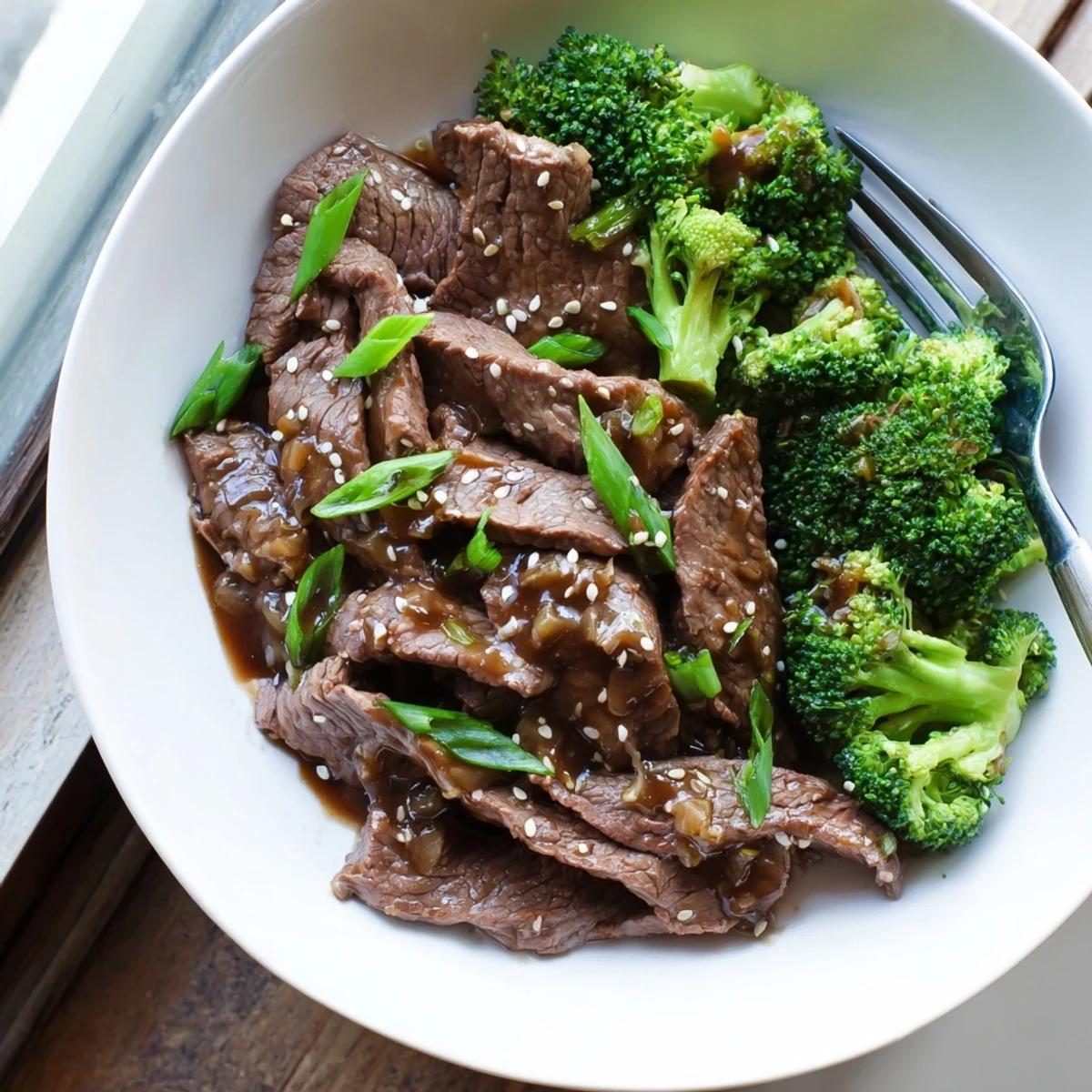 Tender beef strips and crisp broccoli florets coated in savory brown sauce drizzled over white rice