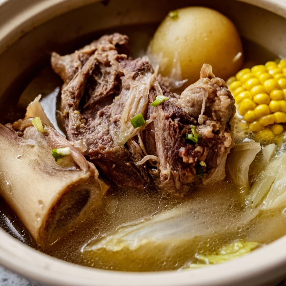 Filipino Bulalo beef shank soup served with corn, cabbage, and rich bone marrow
