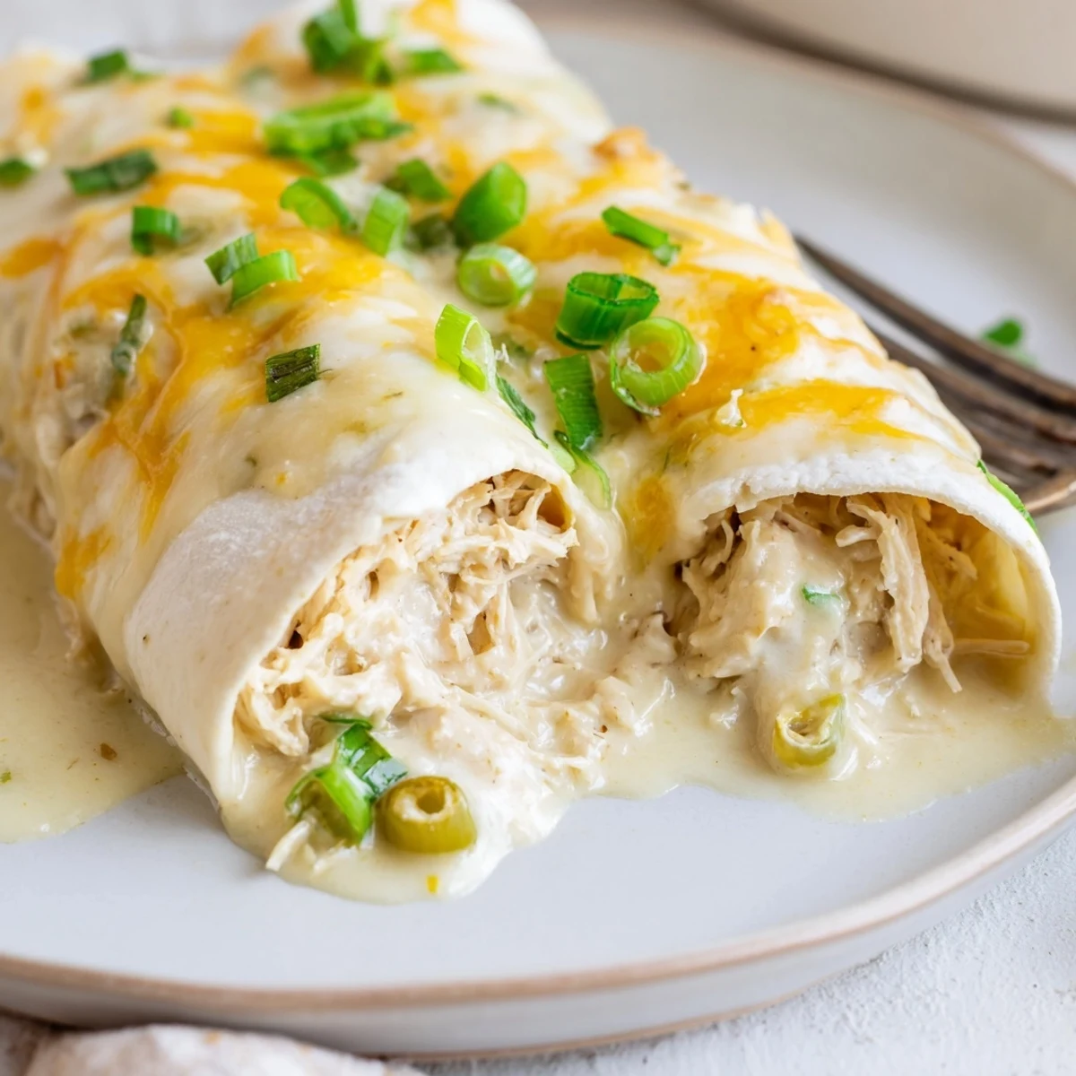 Fresh from the oven, Creamy White Chicken Enchiladas melting cheese, steaming and ready.
