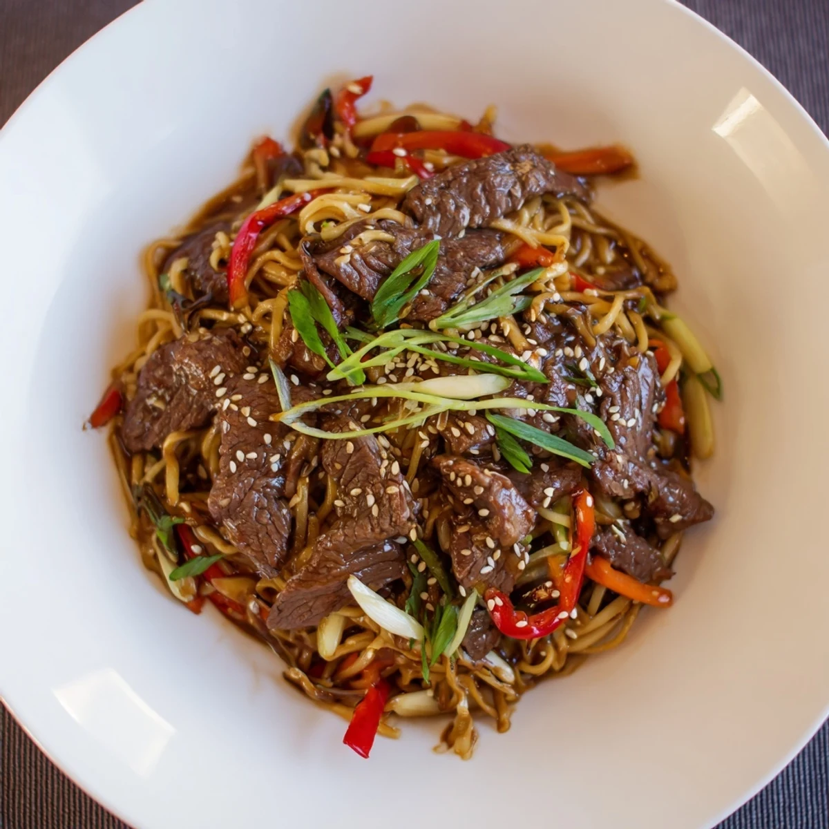 Sticky Beef Noodles served hot from the wok, honey-sweet glaze, sesame seeds