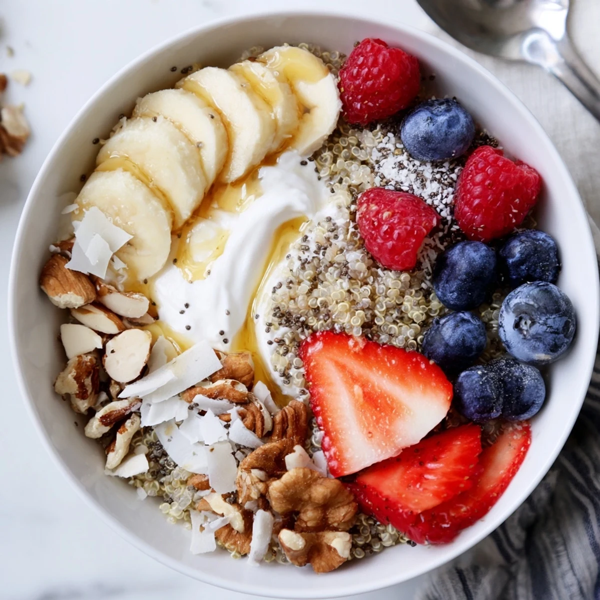 Colorful morning dish arranged for two with berries, coconut flakes: Quinoa Breakfast Bowl