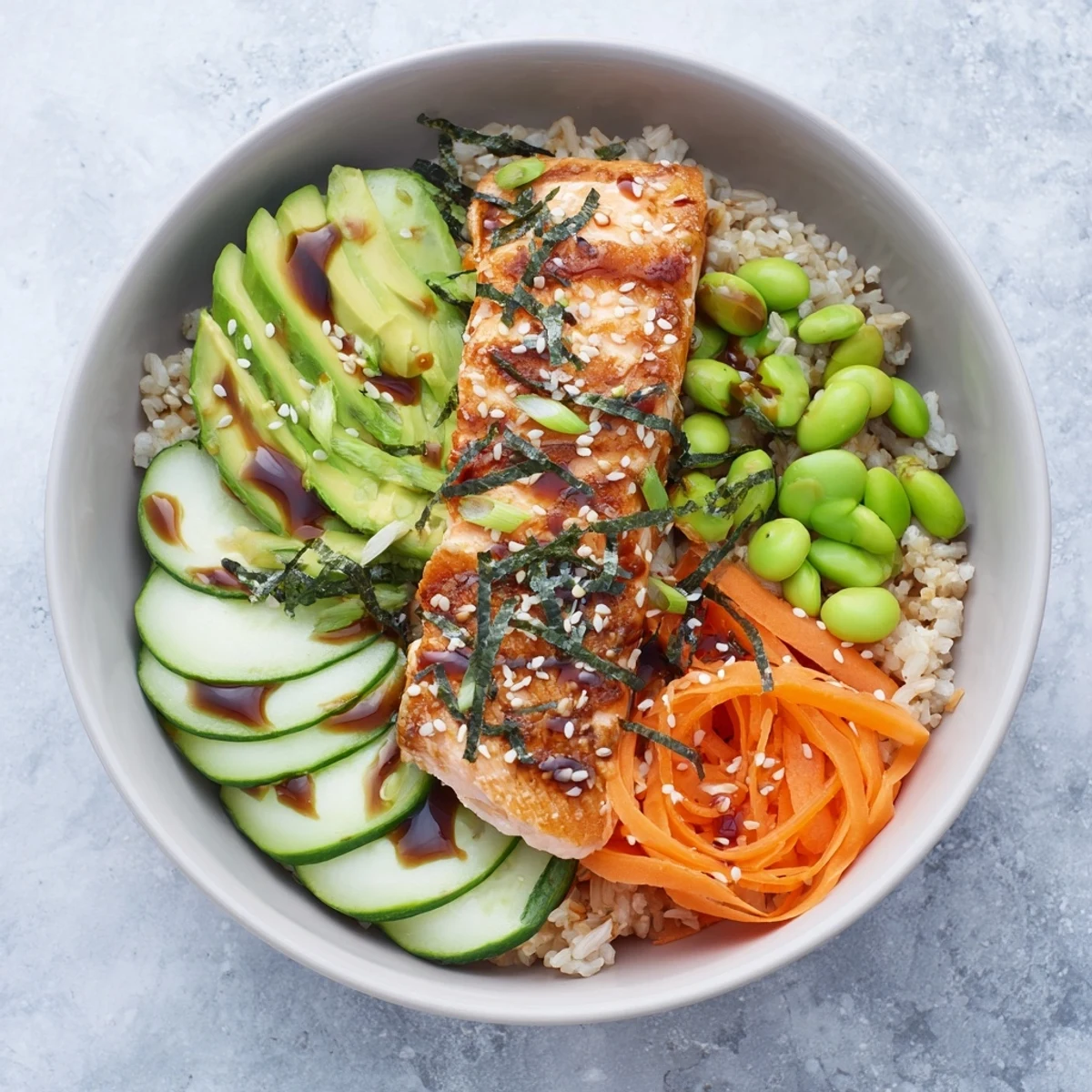 Vibrant salmon and rice bowl featuring flaky crispy fish, crunchy vegetables, and tangy honey sriracha drizzle
