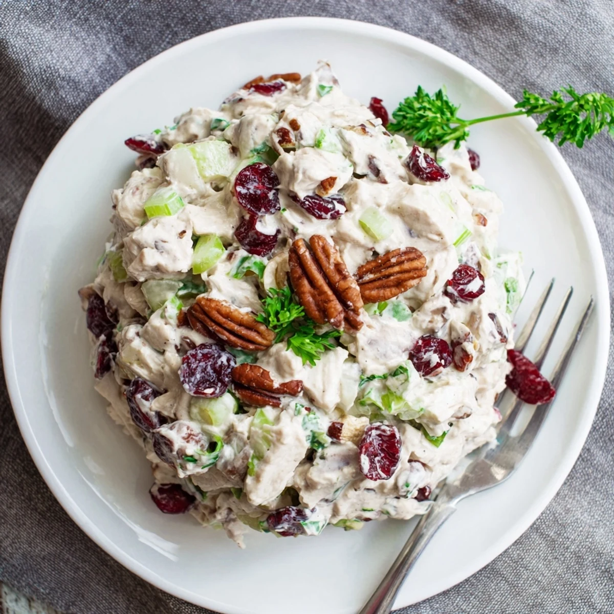 Creamy cranberry pecan chicken salad served in a white bowl with toasted pecans and dried cranberries visible