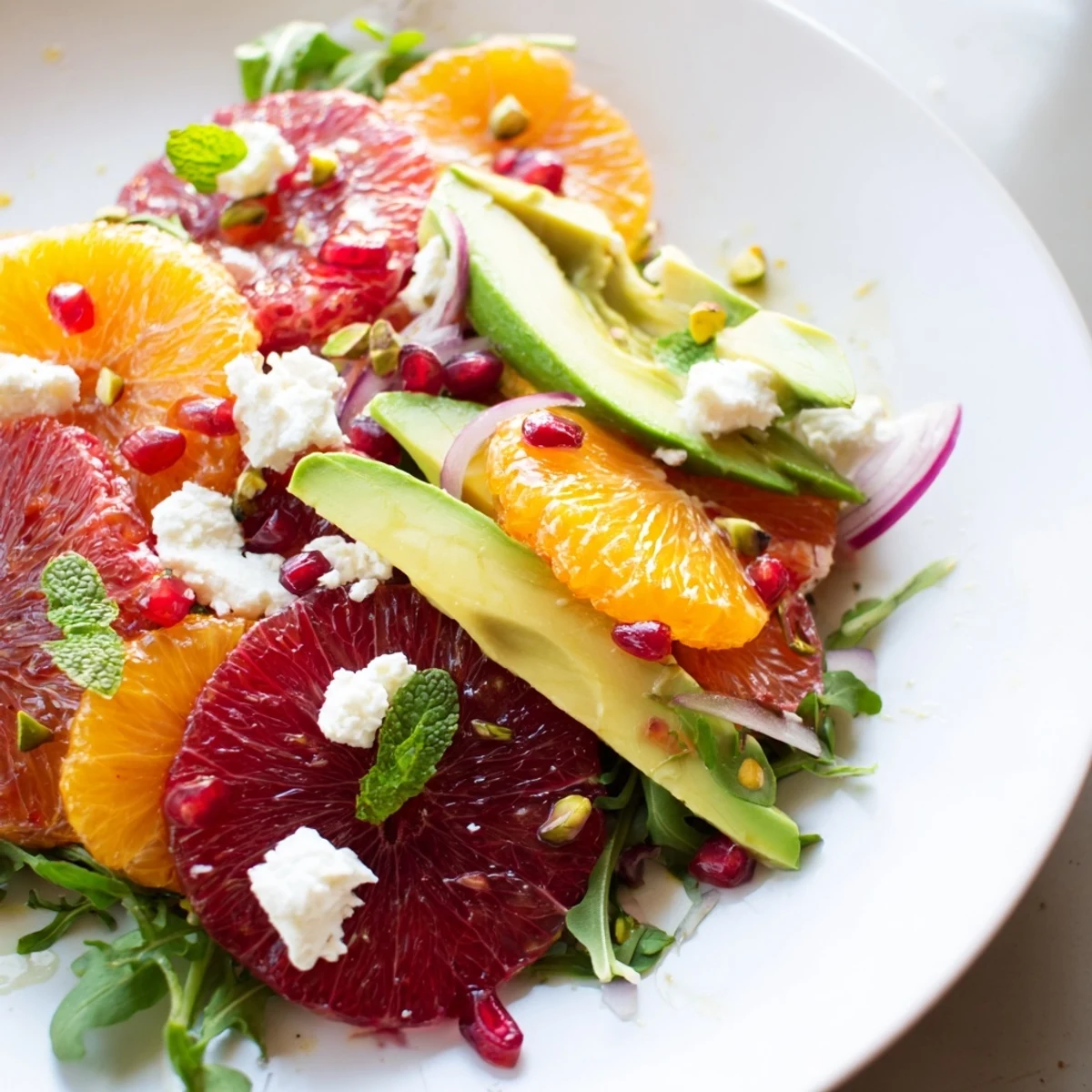 Bright citrus salad topped with jewel-like pomegranate, creamy avocado slices, and crumbled feta cheese