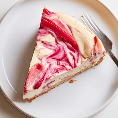 Tangy rhubarb compote ribbons swirled through a rich slice of keto cheesecake